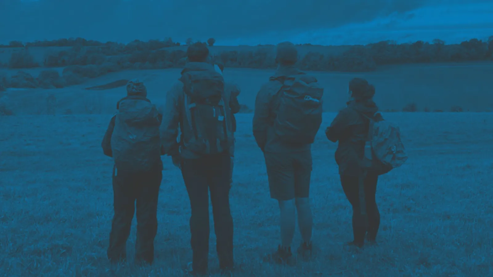 A group of people walking in the countryside looking at the view - Funding for projects that tackle issues of inclusion in nature and wild places