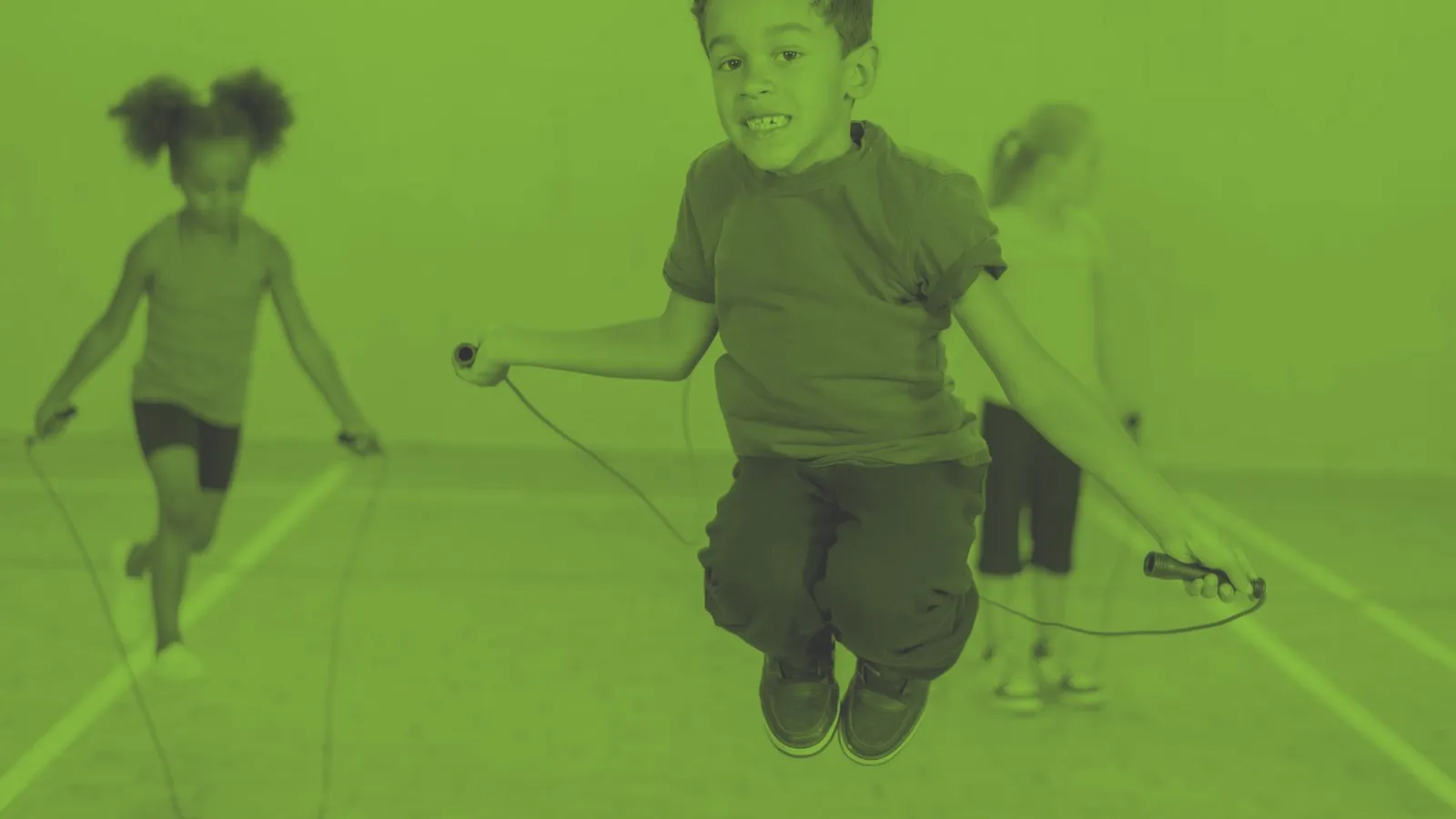 A photograph of children skipping with play equipment - Opportunities for children at Oval Learning schools